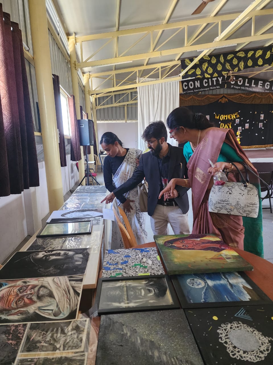 Visitors interacting with paintings at women’s art exhibition
